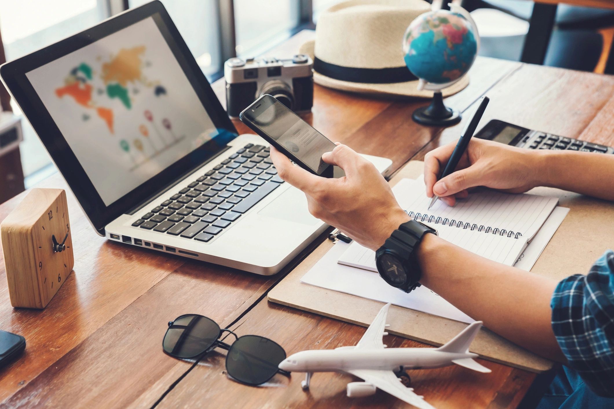 Traveler planning a trip with a laptop and map