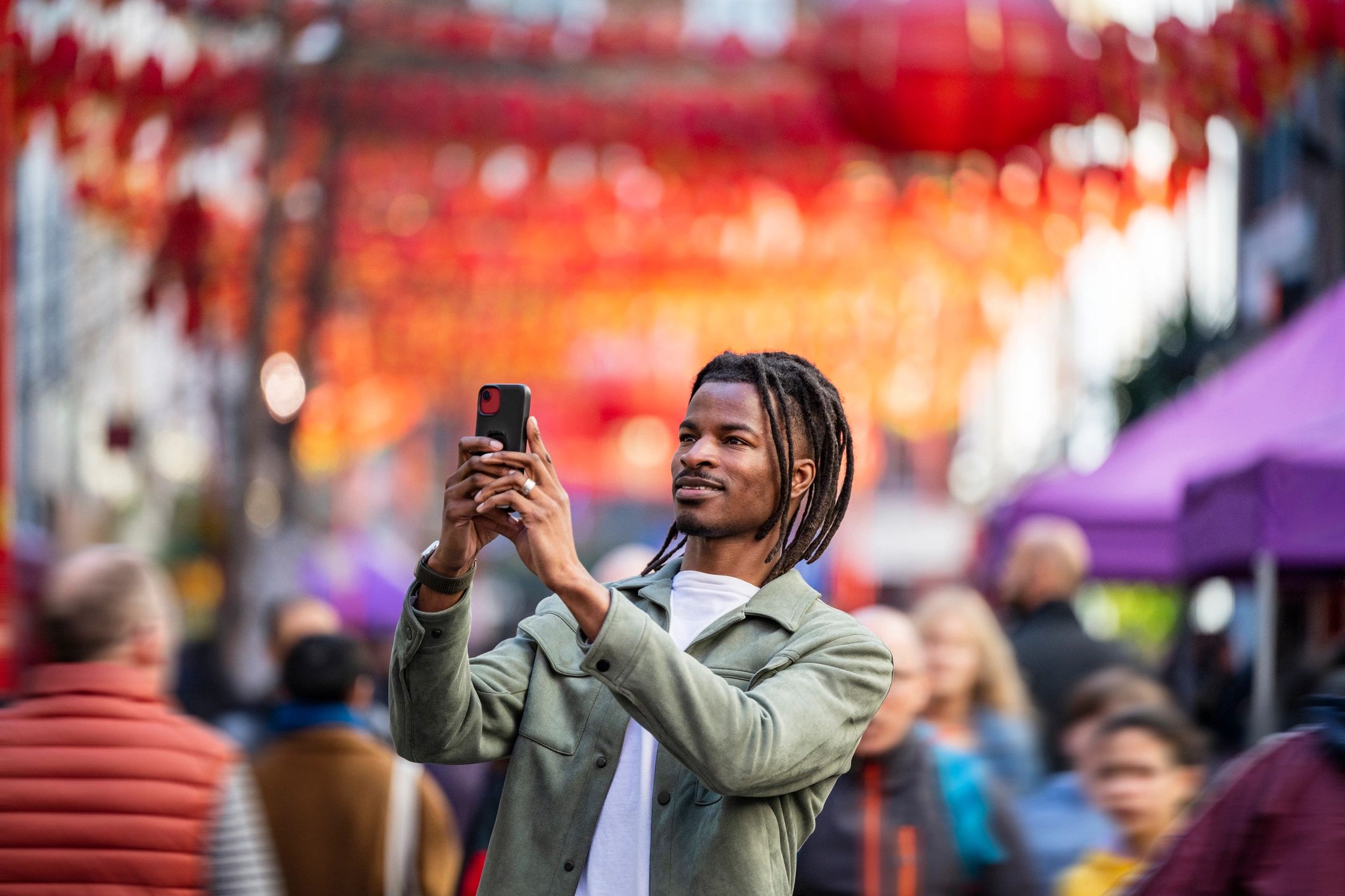 Traveler photographing lanterns in a city street