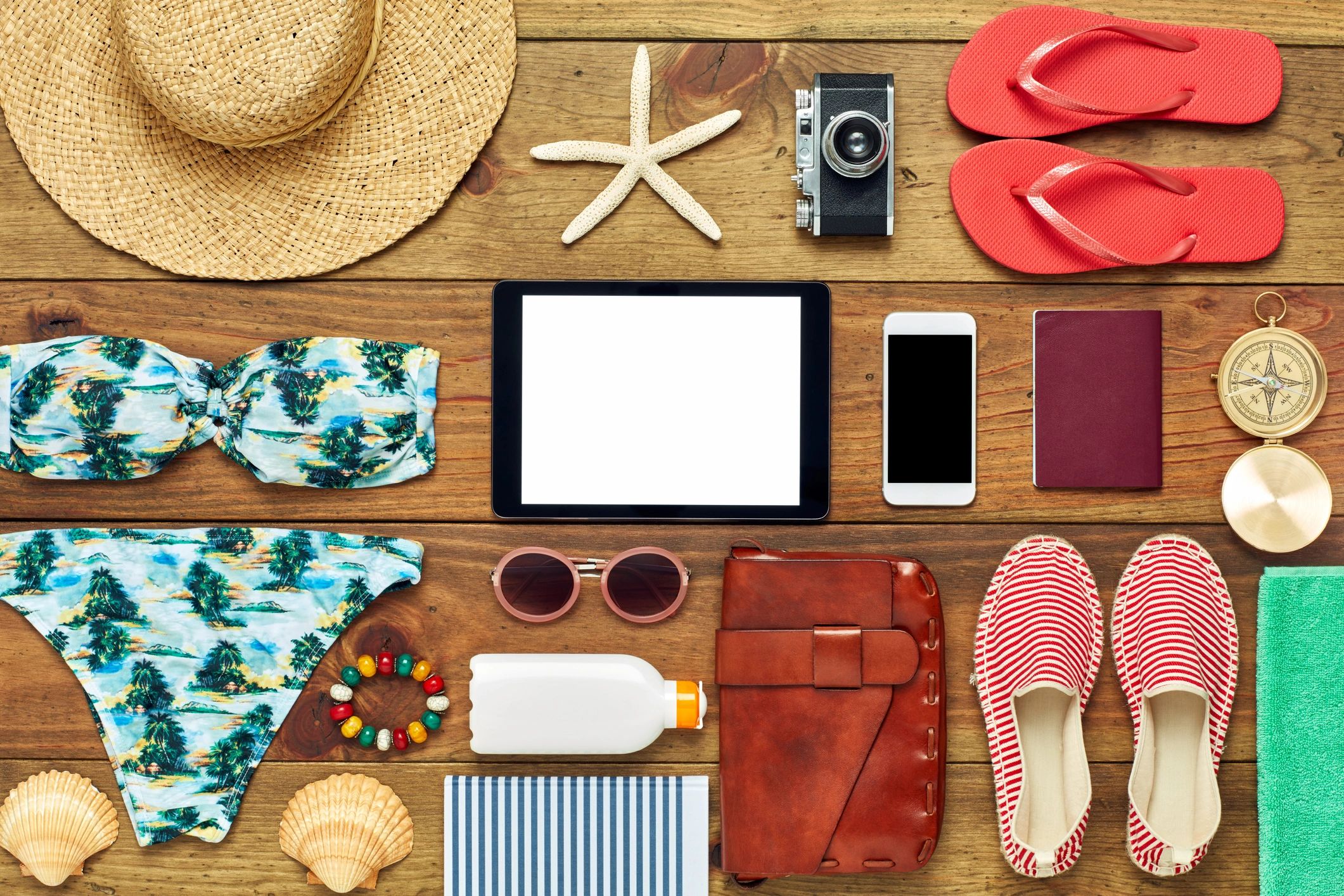 Tablet with travel accessories in a flat lay composition